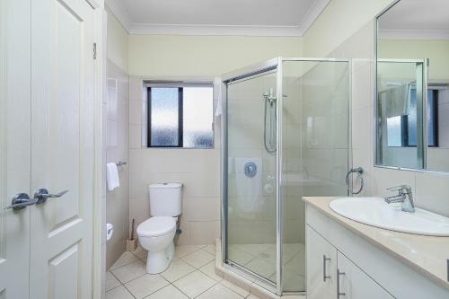 a bathroom with a shower and a toilet and a sink at La Vida on Anzac in Redcliffe