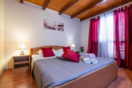 a bedroom with a large bed with red curtains at Apartments with parking space Vela Luka, Korcula - 20932 in Vela Luka