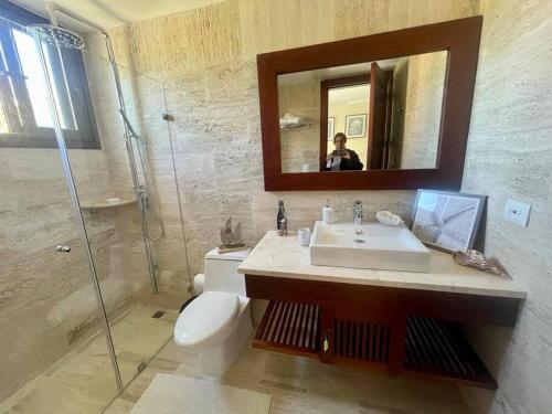 La salle de bains est pourvue d'un lavabo, de toilettes et d'un miroir. dans l'établissement Hermoso apartamento en Portillo ,Las Terrenas, à El Limón