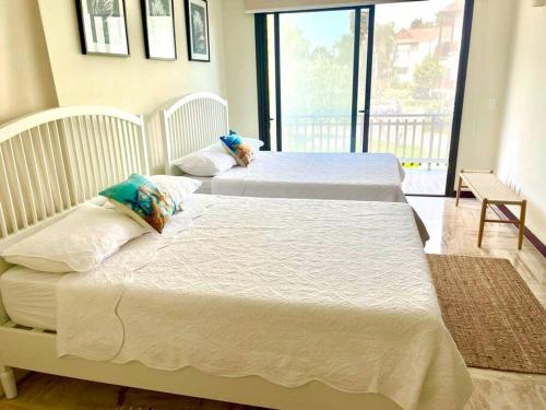 - 2 lits blancs dans une chambre avec balcon dans l'établissement Hermoso apartamento en Portillo ,Las Terrenas, à El Limón