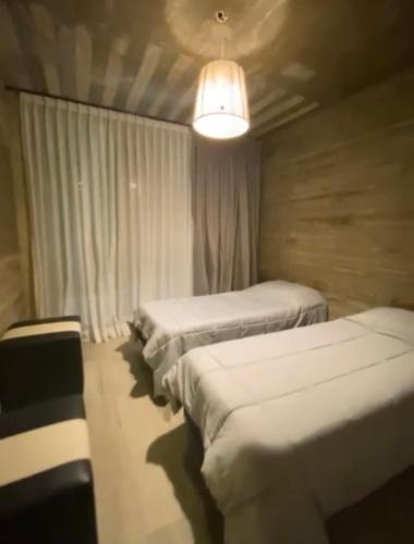 a room with three beds and a light at Monte Hermoso in Monte Hermoso
