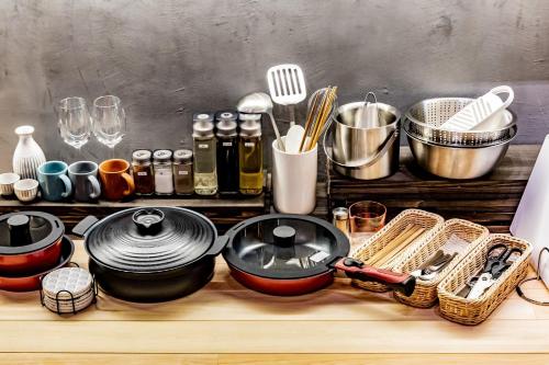 a counter with pots and pans and other kitchen utensils at Uwanosora Bed&BBQ&Sauna in Shizuoka