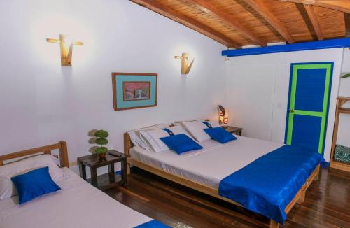 a bedroom with two beds and a blue door at La Casita del Sendero in Calarcá