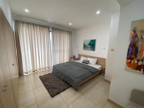 sypialnia z łóżkiem i dużym oknem w obiekcie Ultramodern 2 bedroom space Available w Akrze