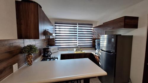a kitchen with a stainless steel refrigerator and a counter at Vistas Pátzcuaro 202 in Pátzcuaro