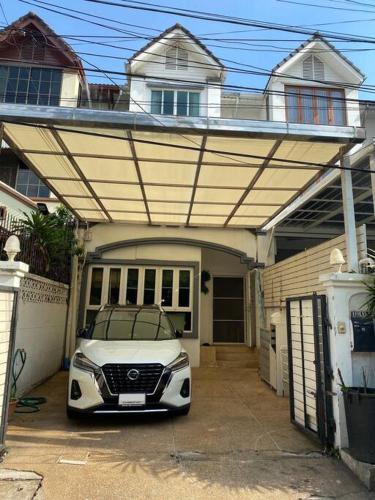 a car is parked under a covered garage at Huge Living Room + 5 bedrooms with Private baths in Bangkok