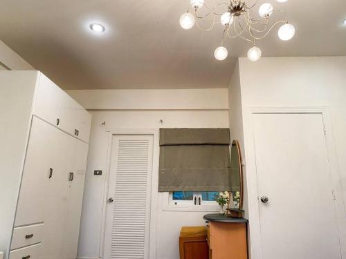 a kitchen with a chandelier and a door with a window at Huge Living Room + 5 bedrooms with Private baths in Bangkok