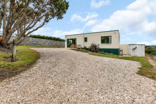 a house with a gravel driveway at The Mermaid's Rest - Whatuwhiwhi Holiday Home in Kaitaia
