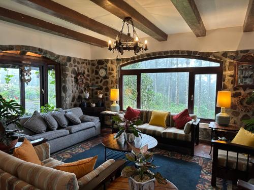 a living room with couches and a large window at Cerro Azul Mountain Retreat in Cerro Azul