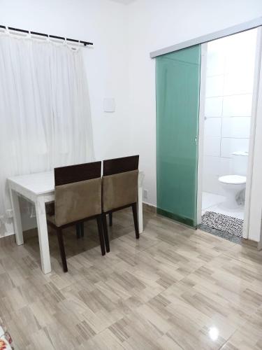 a room with a table and a bench and a bathroom at Residencial Vila Maria in Brasilia