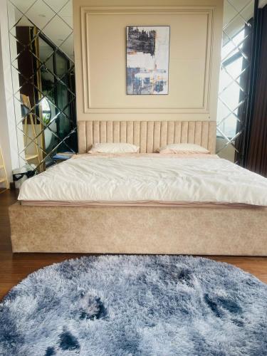 a bedroom with a large bed with a blue rug at ND Happy House 1- CH sân vườn, CH chuẩn khách sạn tại số 10 ngách 5 ngõ 56 Hoa Lâm, Hà Nội in Hanoi