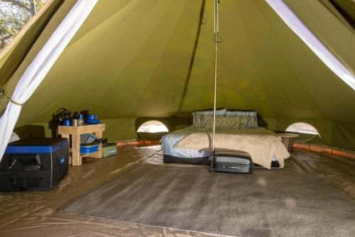 a tent with a bed and a tv in it at Eureka Station Camping Retreat in Apple Tree Creek