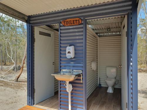 La salle de bains est pourvue de toilettes et d'un lavabo. dans l'établissement Eureka Station Camping Retreat, à Apple Tree Creek