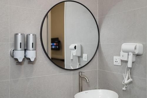 a mirror above a sink in a bathroom at Hotel Luma Senawang in Seremban