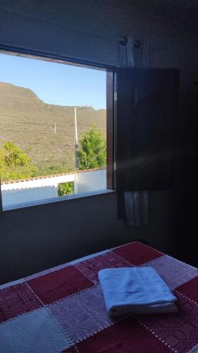 a bedroom with a window and a bed with a blanket at Piatã Chapada Diamantina (Casa da Mãe) in Piatã