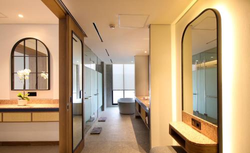 ein Badezimmer mit einer Badewanne, einem WC und einem Waschbecken in der Unterkunft Hotel Santika Premiere Linggarjati - Kuningan in Kuningan