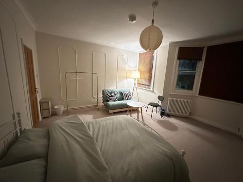 - une chambre avec un lit, un canapé et une chaise dans l'établissement Spacious room near underground, à Londres