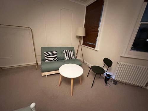 - un salon avec un canapé, une table et des chaises dans l'établissement Spacious room near underground, à Londres