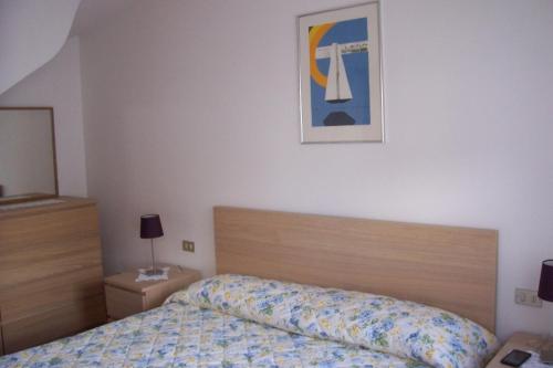 1 dormitorio con 1 cama y una foto en la pared en Fabbricato Indipendente Centro, en Lozzo Cadore