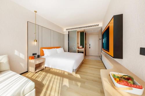 a hotel room with a bed and a bowl of fruit at Real Joy Light in Shenzhen