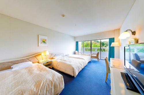 ein Hotelzimmer mit 2 Betten und einem TV in der Unterkunft Ooedo Onsen Monogatari Hotel Reoma no Mori in Marugame