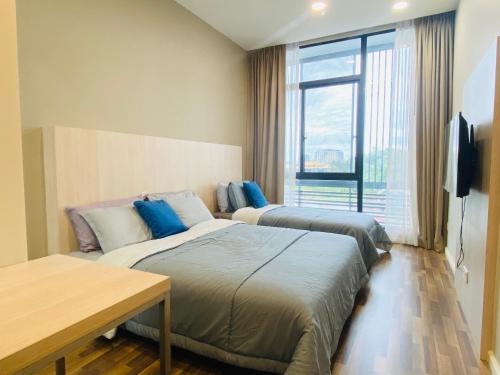 a hotel room with two beds and a television at 2BD @ USS & Car (Optional) in Kuching