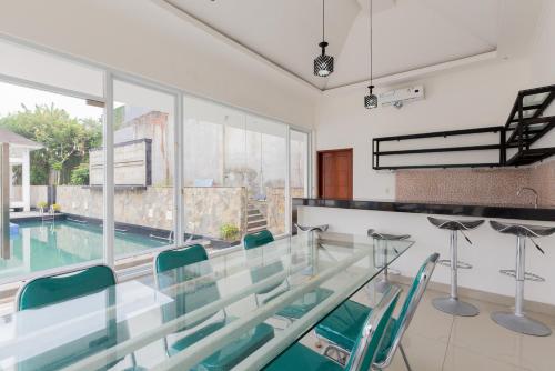 a glass table and chairs in a room with a swimming pool at RedDoorz Premium near Stasiun Lenteng Agung in Jakarta