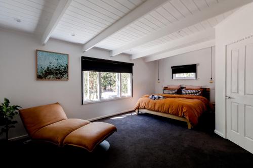 a bedroom with a bed and a chair and a window at Barn Haus in Margaret River Town