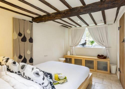 a bedroom with a white bed and a window at Culls Cottage, in Southrop