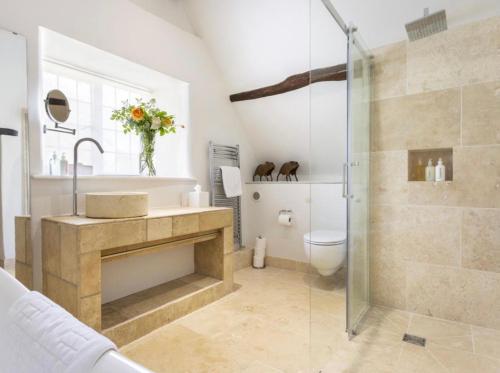 a bathroom with a shower and a sink and a toilet at Culls Cottage, in Southrop