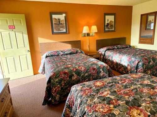 una camera d'albergo con due letti e una porta di Dickens Country Stays 