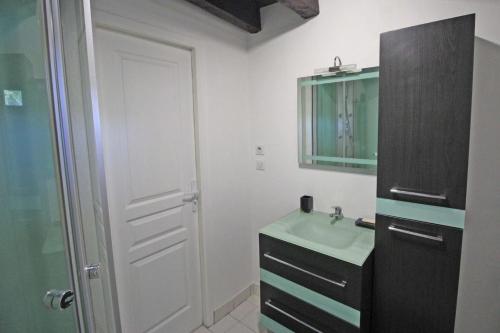 La salle de bains est pourvue d'un lavabo vert et d'un miroir. dans l'établissement Meme jeanne, à Ambazac