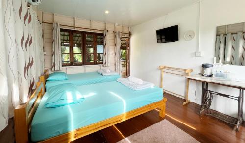a bedroom with a blue bed and a sink at ครูหนูบ้านพัก แหลมงอบ Krunou baanpak in Trat