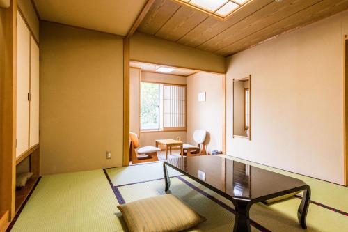 sala de estar con mesa de cristal y sillas en Ooedo Onsen Monogatari Masuya, en Osaki