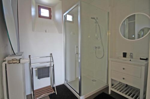 ein weißes Bad mit einer Dusche und einem Waschbecken in der Unterkunft Tata therese in Ambazac