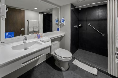 a bathroom with a sink and a toilet and a shower at City Express by Marriott Tepic in Tepic