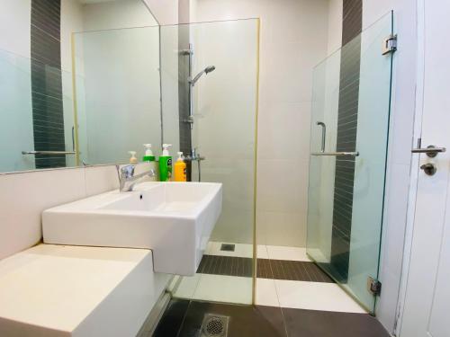 a bathroom with a sink and a glass shower at 2BD @ USS & Car (Optional) in Kuching