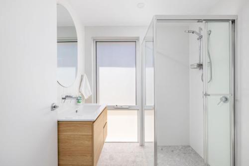 淺灘灣的住宿－Shoal Bay Beach House One，带淋浴、盥洗盆和镜子的浴室