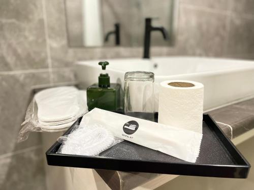 a black tray with toilet paper and a sink at Kingston Hotel Kuala Lumpur in Kuala Lumpur