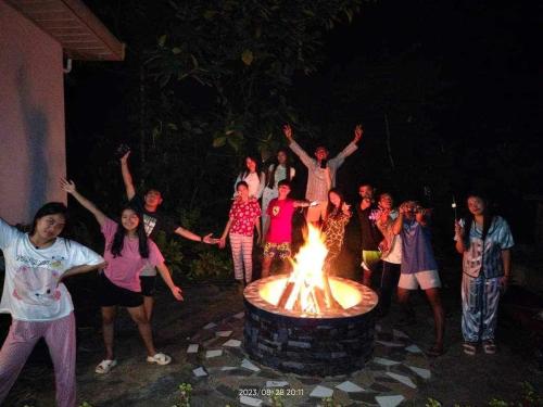 eine Gruppe von Menschen, die um eine Feuerstelle stehen in der Unterkunft CROSSROADS HAVEN FARM in Majayjay