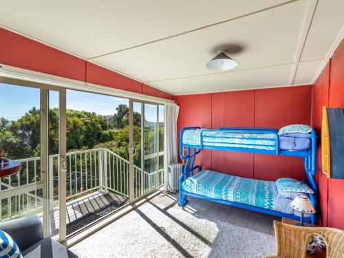 sypialnia z łóżkiem piętrowym i balkonem w obiekcie Beachhouse View w mieście Riverton