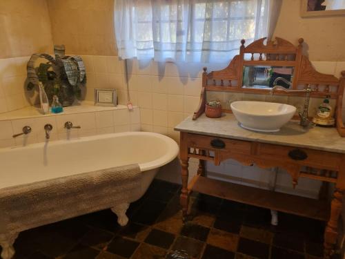 a bathroom with a bath tub and a sink at Sandalmere Cottage in Cadell