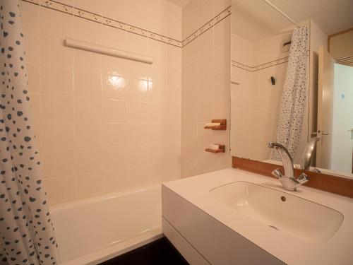 ein weißes Badezimmer mit einem Waschbecken und einer Badewanne in der Unterkunft Appartement Valmorel, 1 pièce, 4 personnes - FR-1-356-258 in Valmorel
