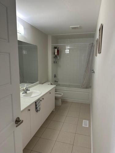bagno con lavandino, vasca e servizi igienici di 4 Bedrooms new house sleep 12 fury friends welcome a Niagara Falls