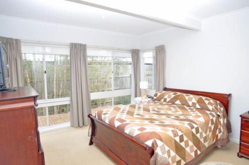 a bedroom with a bed and a large window at Welcome Break Pet Friendly in Inverloch