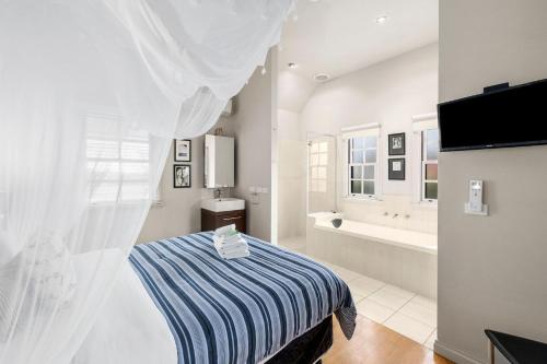 a bedroom with a bed and a bathroom with a tub at Circa Ruby Mint Daylesford in Daylesford