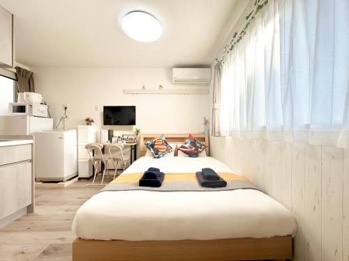 a large bed in a room with a kitchen at nestay apartment tokyo waseda in Tokyo