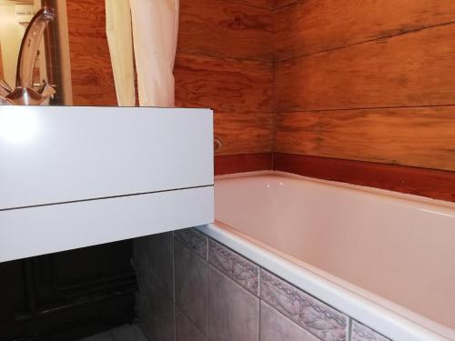 a bath tub in a bathroom with a wooden wall at Appartement Valmorel, 1 pièce, 4 personnes - FR-1-356-350 in Valmorel
