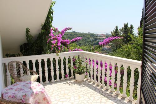 a balcony with a chair and purple flowers at Apartment Dragovic in Ulcinj