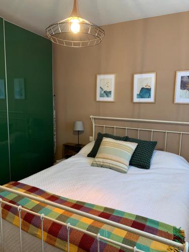 Schlafzimmer mit einem Bett mit grüner Wand in der Unterkunft Apartamento con jardín en Costa Quebrada in Liencres